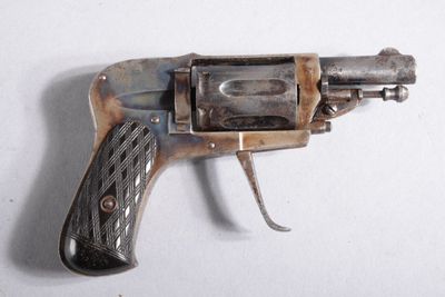 un petit pistolet posé sur une surface blanche