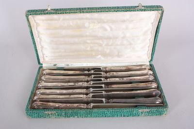 a green case with silverware in it on a white surface