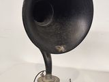 an old black gramphone sitting on a table next to a pair of wires