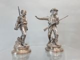 paire de figurines en argent représentant deux hommes armés et un chien