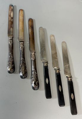 five knives and a knife holder on a table