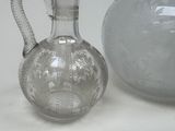 a clear glass pitcher next to a clear glass vase