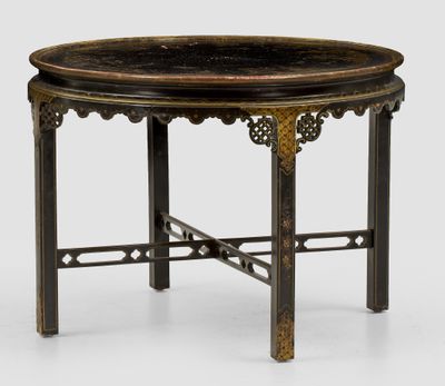 a black and gold table with a circular top on a white surface