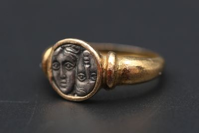une bague en or avec une pièce romaine au centre