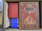 de nombreux livres dans une boîte en carton posée sur le sol