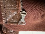 a close up of a zipper on a brown sweater