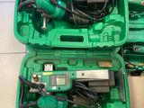 deux outils verts dans un coffret vert posé par terre