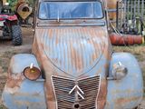 a rusted out old truck parked under a covered structure