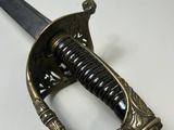 a close up of a sword on a white surface