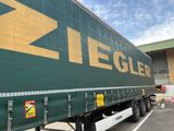 un semi-remorque vert avec une flèche jaune sur le côté