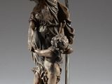 statue of a woman holding a dog and a lamp on a table