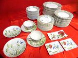 many plates and cups on a table with red cloth