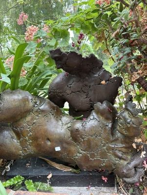 une statue représentant un chien couché sur le dos dans un jardin