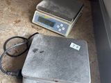 two scales sitting on the floor next to each other