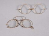 three pairs of gold hoop earrings on a white surface