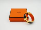 une boîte orange contenant un bracelet noir et doré