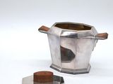 a silver teapot with a wooden lid and a silver teapot with a wooden handle