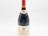 une bouteille de vin posée sur une table, devant un fond blanc