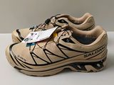 the shoe is tan and black with a tag on it