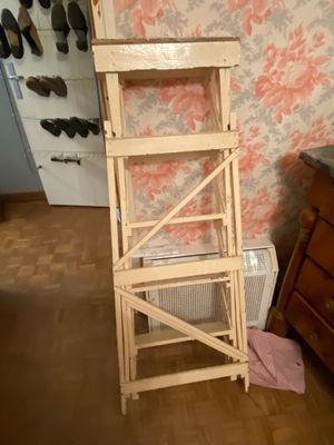 a tall wooden ladder next to a dresser in a room