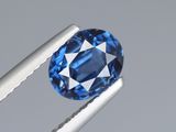 un gros plan d'un saphir bleu tenu par une paire de pinces