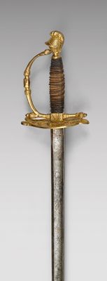 une vieille épée avec une poignée en or sur laquelle est représenté un oiseau