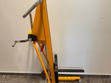 a small yellow crane sitting in a room next to a wall