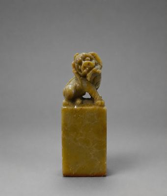 une petite figurine sculptée représentant un lion posée sur un socle