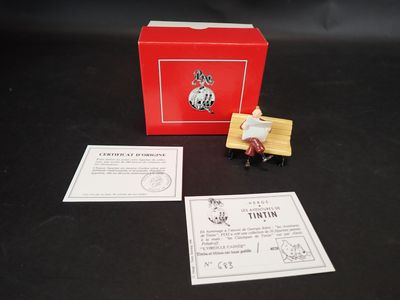 une petite figurine représentant un homme assis sur un banc