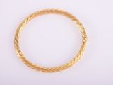 a close up of a gold bracelet on a white surface