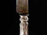 a silver knife that is sitting on top of a table
