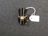 a ring with a pearl on it sitting on a table