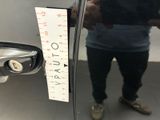 a man that is standing in front of a mirror with a ruler