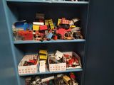a blue bookcase filled with toy cars and other items