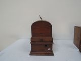 a small wooden clock sitting on a white table