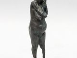 bronze statue of a woman standing on a pedestal with her hands on her hips