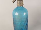 une bouteille en verre bleue munie d'un robinet en métal