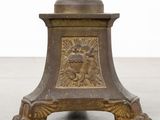 an old bronze vase with a bird on it sitting on a table