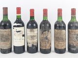 six bottles of wine are lined up in a row on a white surface