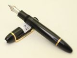 un stylo noir et un stylo doré sur une surface blanche
