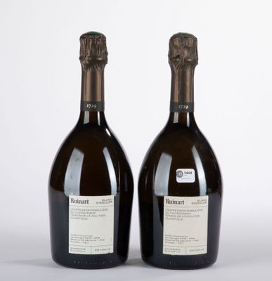 deux bouteilles de vin posées l'une à côté de l'autre sur une surface blanche