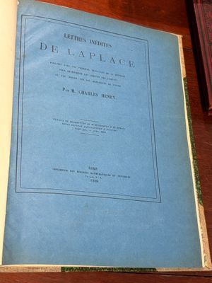 un vieux livre posé sur une table en bois à côté d'une tasse de café