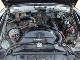 a car engine with its hood open on a dirt road