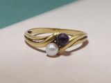 un gros plan d'une bague ornée de deux perles