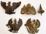 Plusieurs objets anciens en métal sont exposés sur une surface blanche