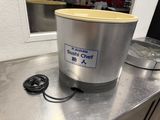 stainless steel counter top with a metal container and a cord plugged into it