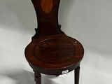 an antique wooden chair with a carved seat and back rest