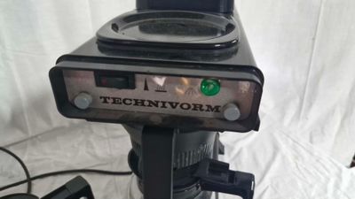 un gros plan d'une cafetière posée sur un trépied