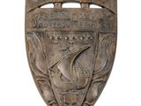 an image of a metal shield with a ship on it