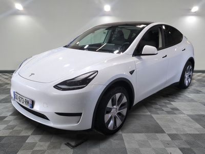 the white tesla suv is parked on a checkered tile floor